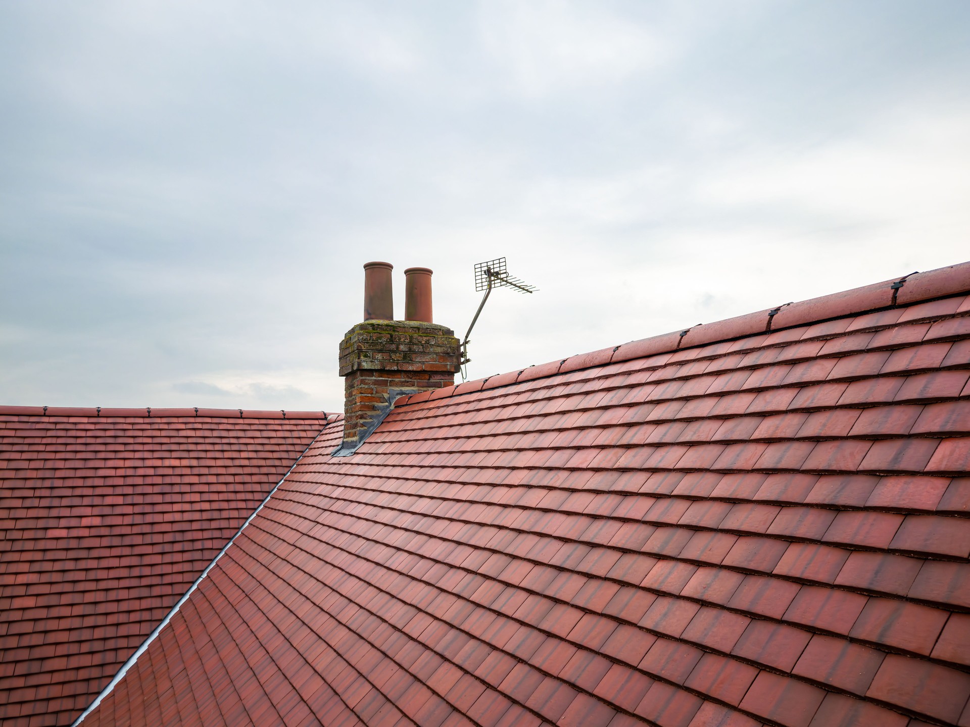 Inspection drone view of a newly installed ceramic roof on an old English farmhouse.